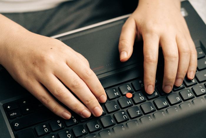 Mains sur le clavier d’un portable